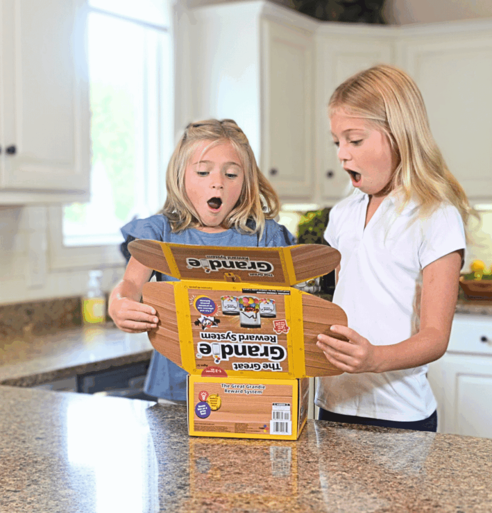 Two children opening The Great Grandie Reward System box and their faces are pure excitement and shock with what they see when they look inside.